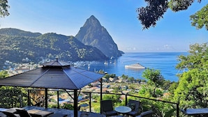 A coastal view with a gazebo, outdoor seating, and a mountain in the background. - Serene Stay, Scenic Views w/ Breakfast & Spa (Palmiste)