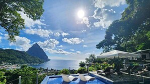 Une piscine avec vue sur l’océan et une montagne.