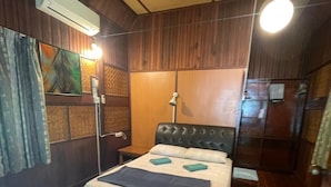 Een kamer met een bed, houten wanden, een airconditioning en een spiegel.