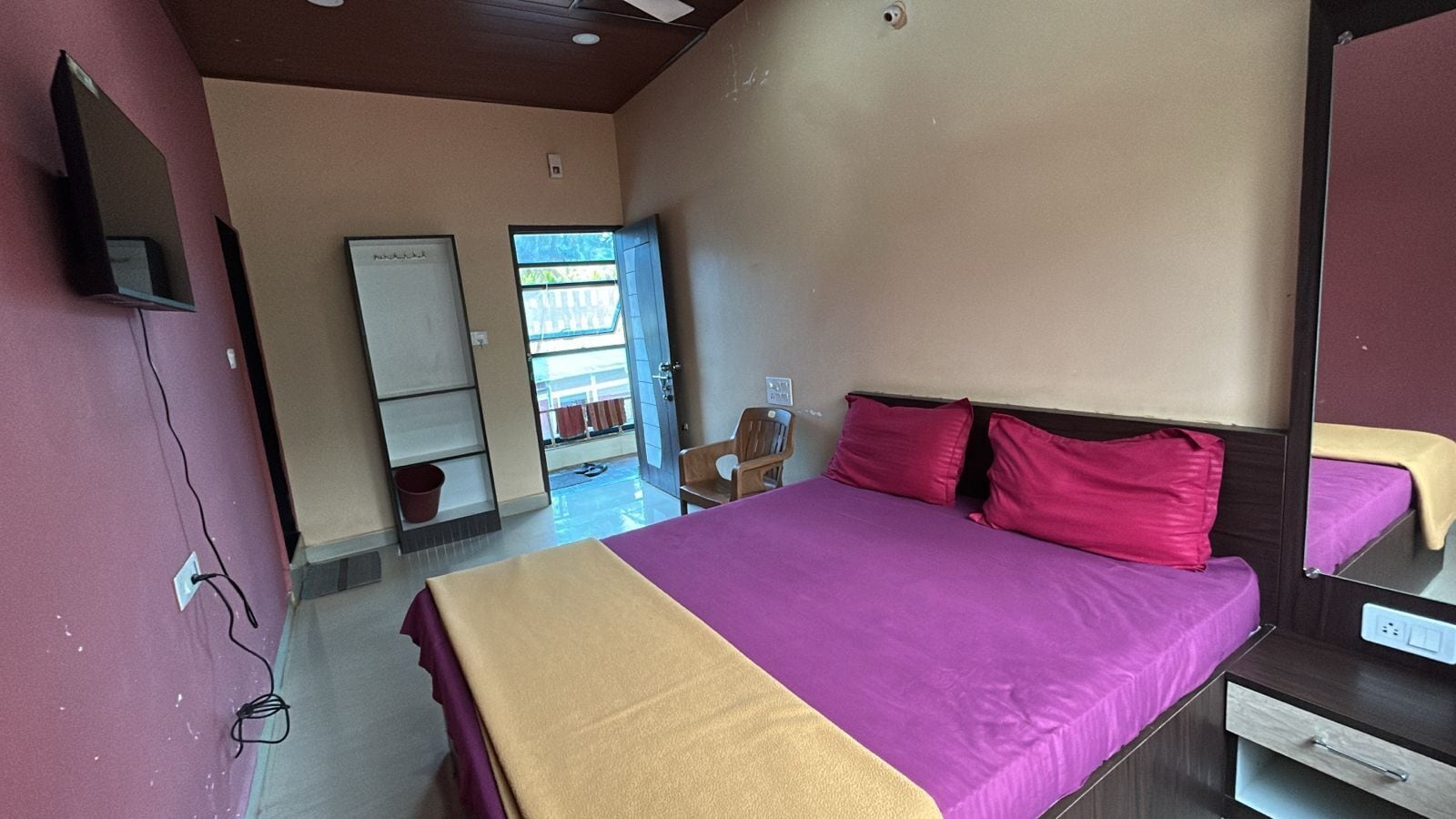 Un dormitorio con cama, escritorio, silla, armario y ventana.
