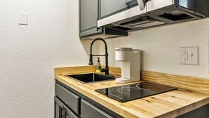 A compact kitchen with a stainless steel microwave, a sink, and wooden countertops. - Cozy stay for 2: 5 Min Drive to Base,  Full Kitchen, Shared Hot Tub & Pool, Restaurants Nearby! (Park City)