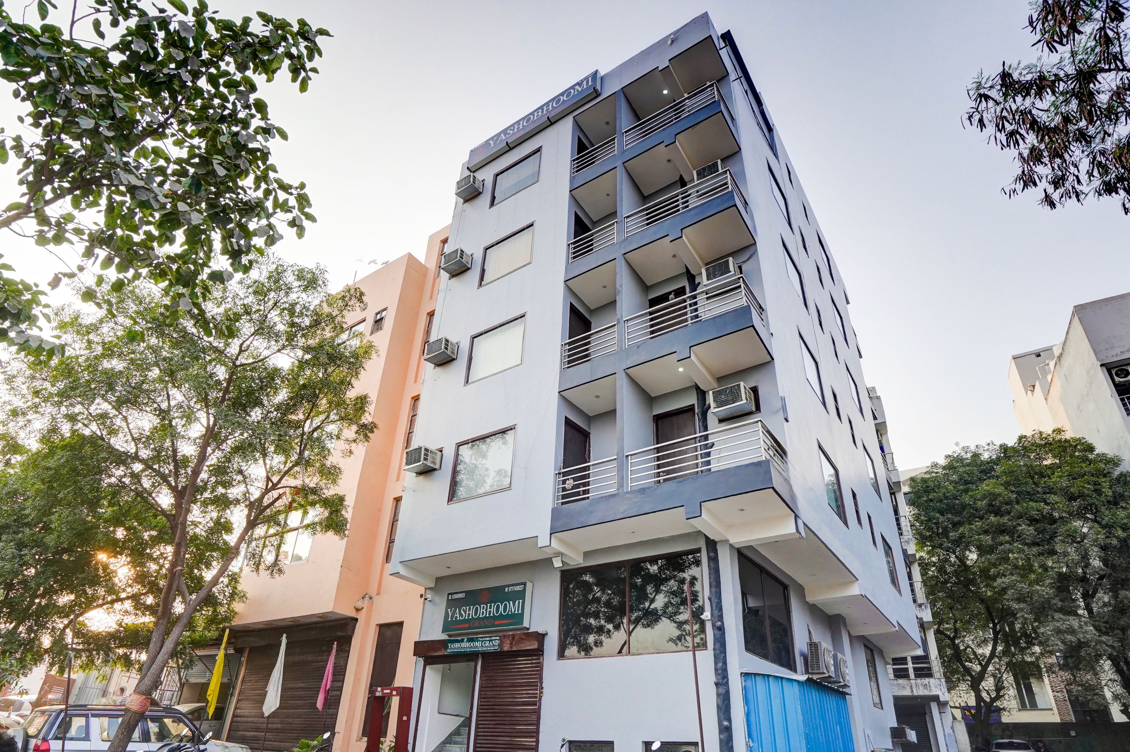 Un edificio de varios pisos con balcones, unidades de aire acondicionado y un letrero que indica que es un hotel.