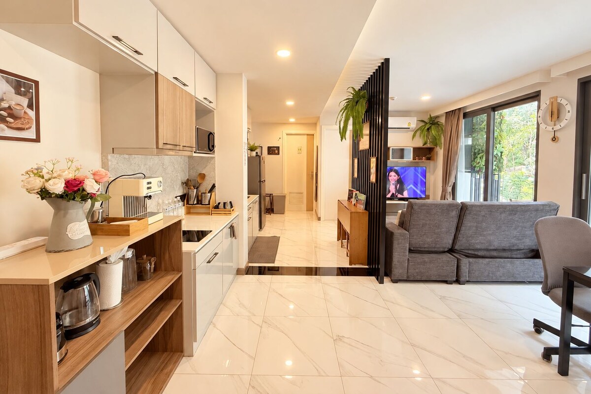 A modern living room with a grey sofa, a coffee table, and a television.
