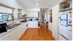 Una cocina con armarios blancos, microondas, tostadora y refrigerador.