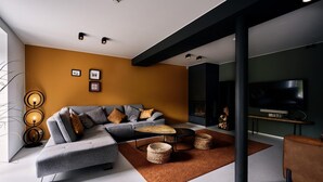 A modern living room with a sectional sofa, a coffee table, and a flat-screen TV.