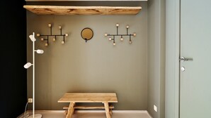 A room with a wooden bench, a floor lamp, and wall-mounted light fixtures.