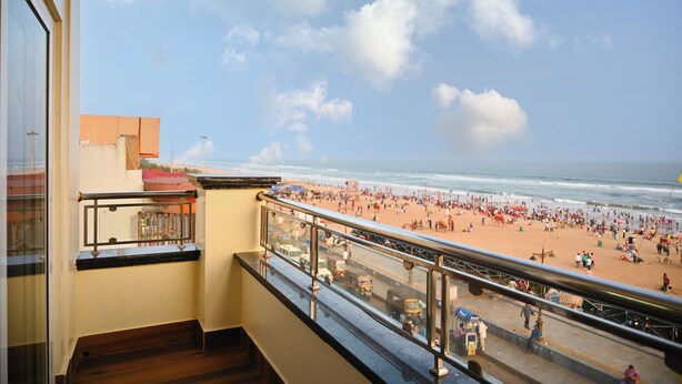 A balcony with a view of a crowded beach and the ocean. -  ECKO Beach Front, Puri (Puri)