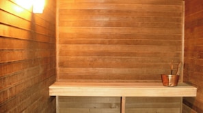 Un sauna avec des murs en bois et un banc.