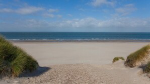 En strand med klart skys og roligt hav.