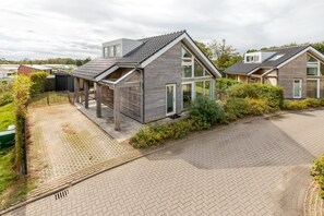 A modern residential area with two houses featuring pitched roofs and large windows.