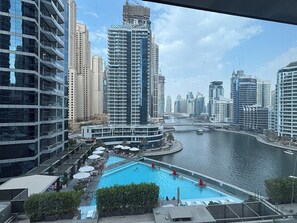 A high-rise building with a swimming pool and a river in the background.