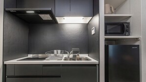 Une cuisine moderne équipée d’un évier en acier inoxydable, d’un four à micro-ondes et d’un réfrigérateur Hisense.