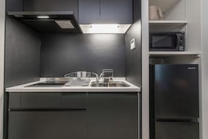 Una cocina moderna con un lavamanos de acero inoxidable, un microondas y un refrigerador Hisense.