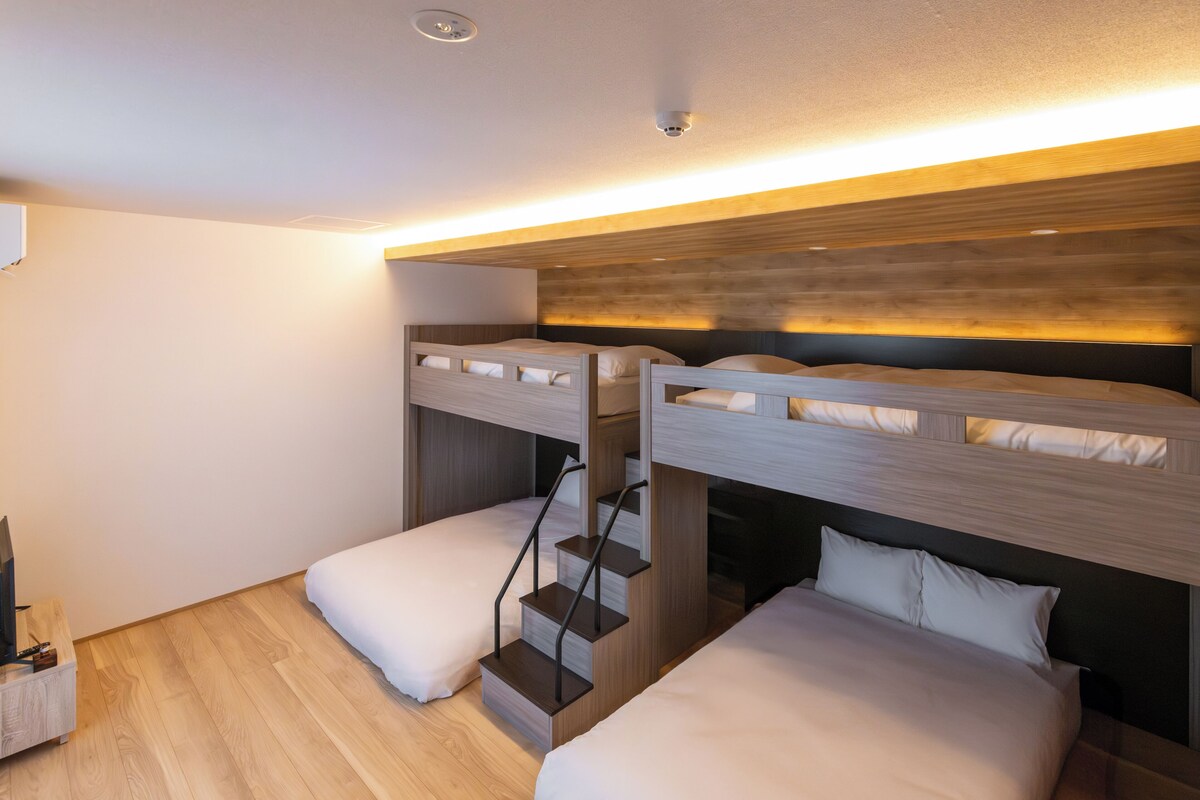 Habitación con literas, una escalera y una cama nido.