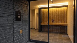 Un ascenseur moderne doté d’une porte en verre, d’un mur revêtu de panneaux en bois et d’un panneau indiquant le numéro de l’étage.