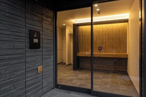 Un moderno ascensor con puerta de vidrio, pared revestida de madera y un cartel que indica el nivel del piso.