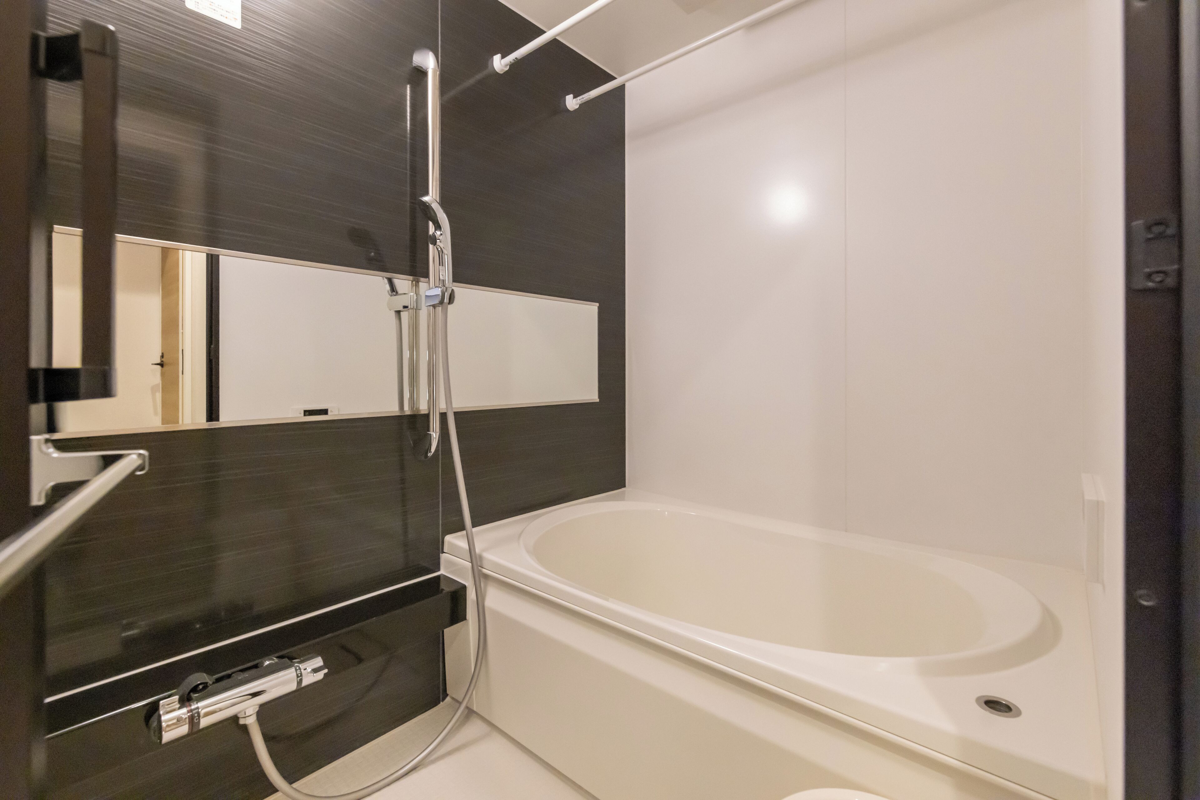 Un baño moderno con una bañera grande, un cabezal de ducha y un espejo.