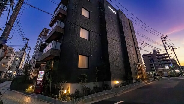 Un bâtiment moderne à plusieurs étages, doté de grandes fenêtres et d’une entrée bien visible.