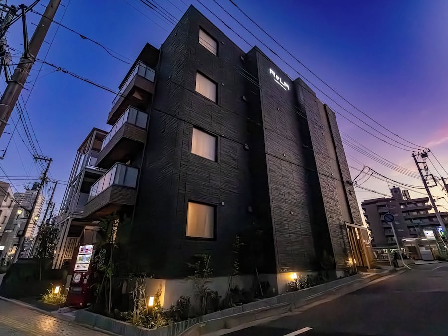 A modern building with multiple floors, large windows, and a visible entrance.
