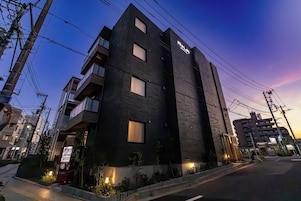 Un edificio moderno de varios pisos, con amplias ventanas y una entrada visible.