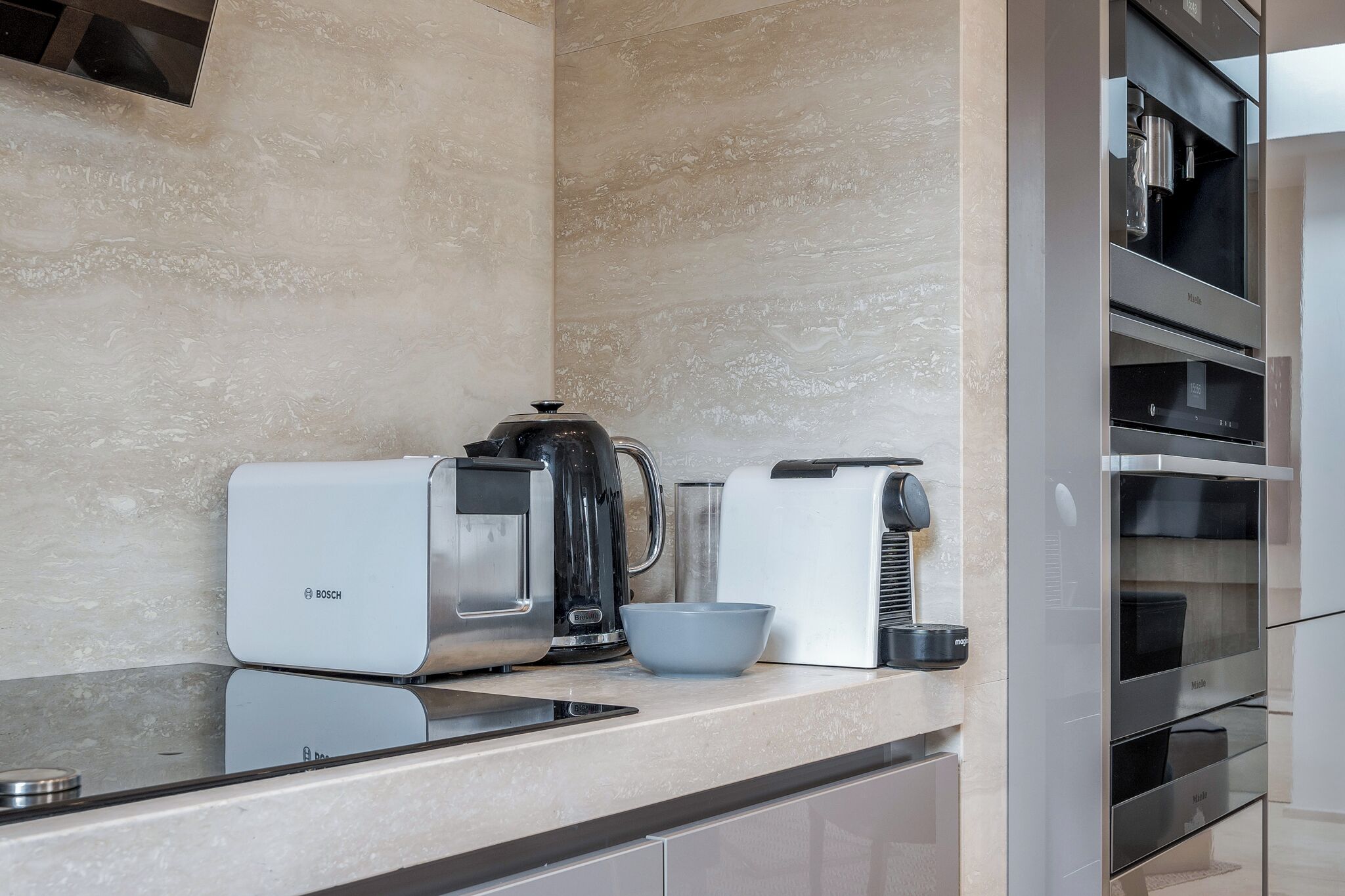 A modern kitchen with a Bosch coffee maker, a kettle, and a toaster.