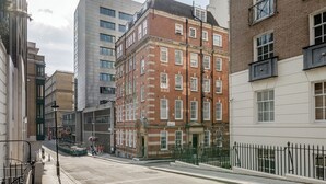 Un edificio de varios pisos con fachada de ladrillo, ventanas grandes y techo plano.
