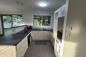 A compact kitchen with a sink, stove, and microwave.