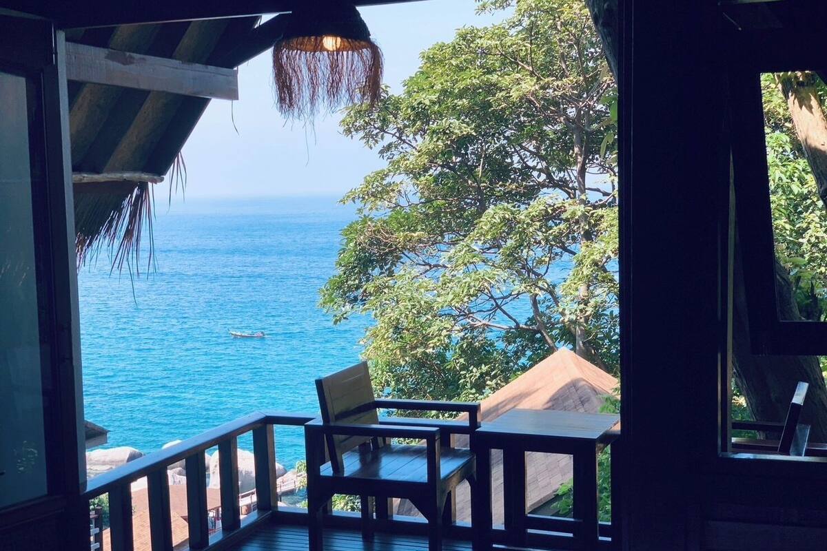 A wooden deck with a view of the ocean and a boat.