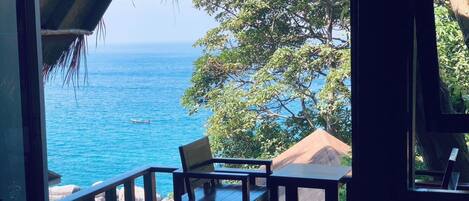 A wooden deck with a view of the ocean and a boat.