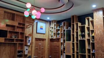 A room with wooden shelving units, a ceiling fan, and a mounted television.