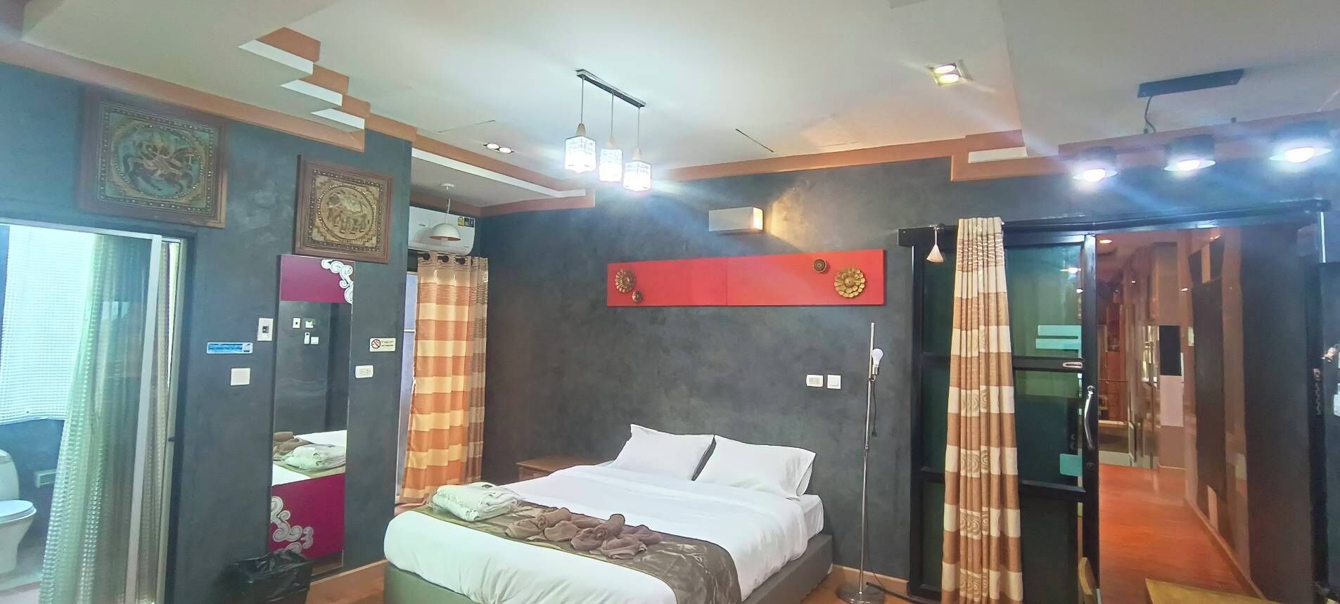 Ett hotellrum med en säng, ett skrivbord, en stol, en garderob och ett badrum.
