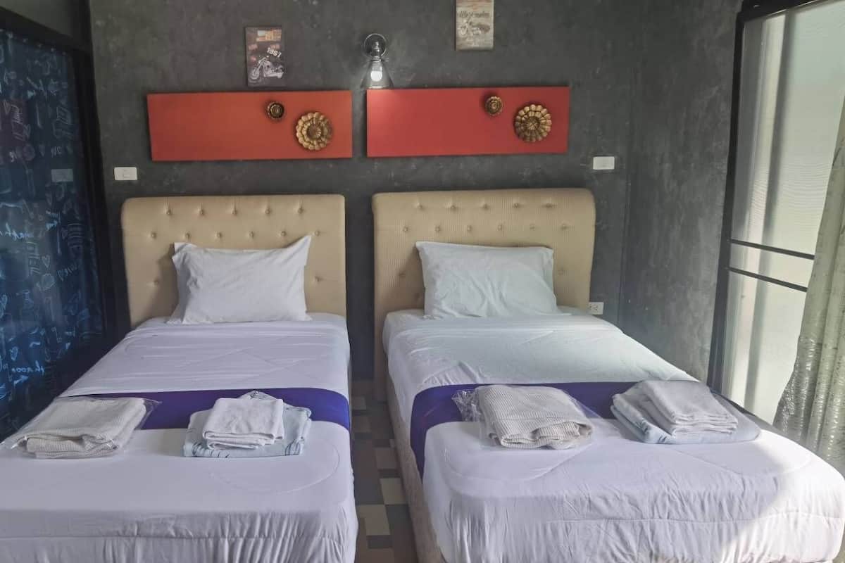 A hotel room with two beds, a bathroom, and a view of the city.