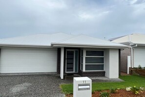 A modern single-story house with a garage, a front door, and a mailbox. - 4 Bedroom House, Master with ensuite and A/C (Flagstone)