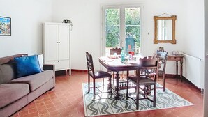 A dining area with a table, chairs, and a ceiling fan.