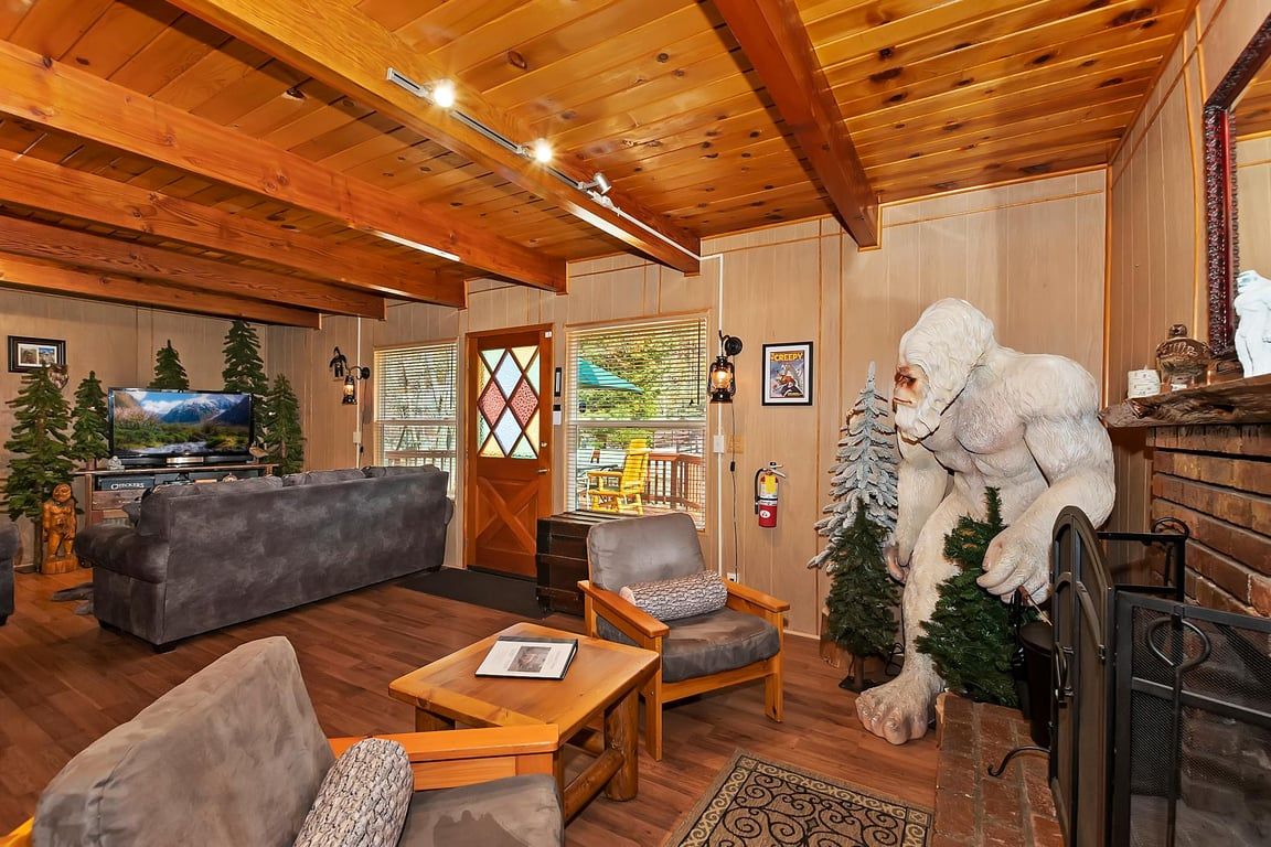 A cozy living room with a fireplace, a television, and a large sofa.
