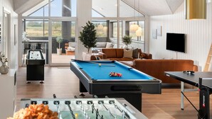 A spacious living area with a pool table, foosball table, and a comfortable seating area with a couch and chairs. - Lovely home in Idestrup with sauna (Idestrup)