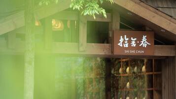 A traditional wooden building with a sign reading "SHI SHE CHUN".