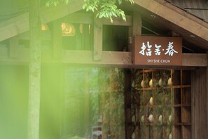 A traditional wooden building with a sign reading "SHI SHE CHUN".