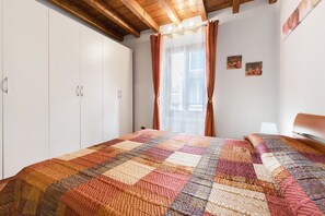 Une chambre avec un grand lit, une armoire et une fenêtre avec des rideaux.