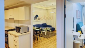 A modern apartment with a kitchen, dining area, and living room.