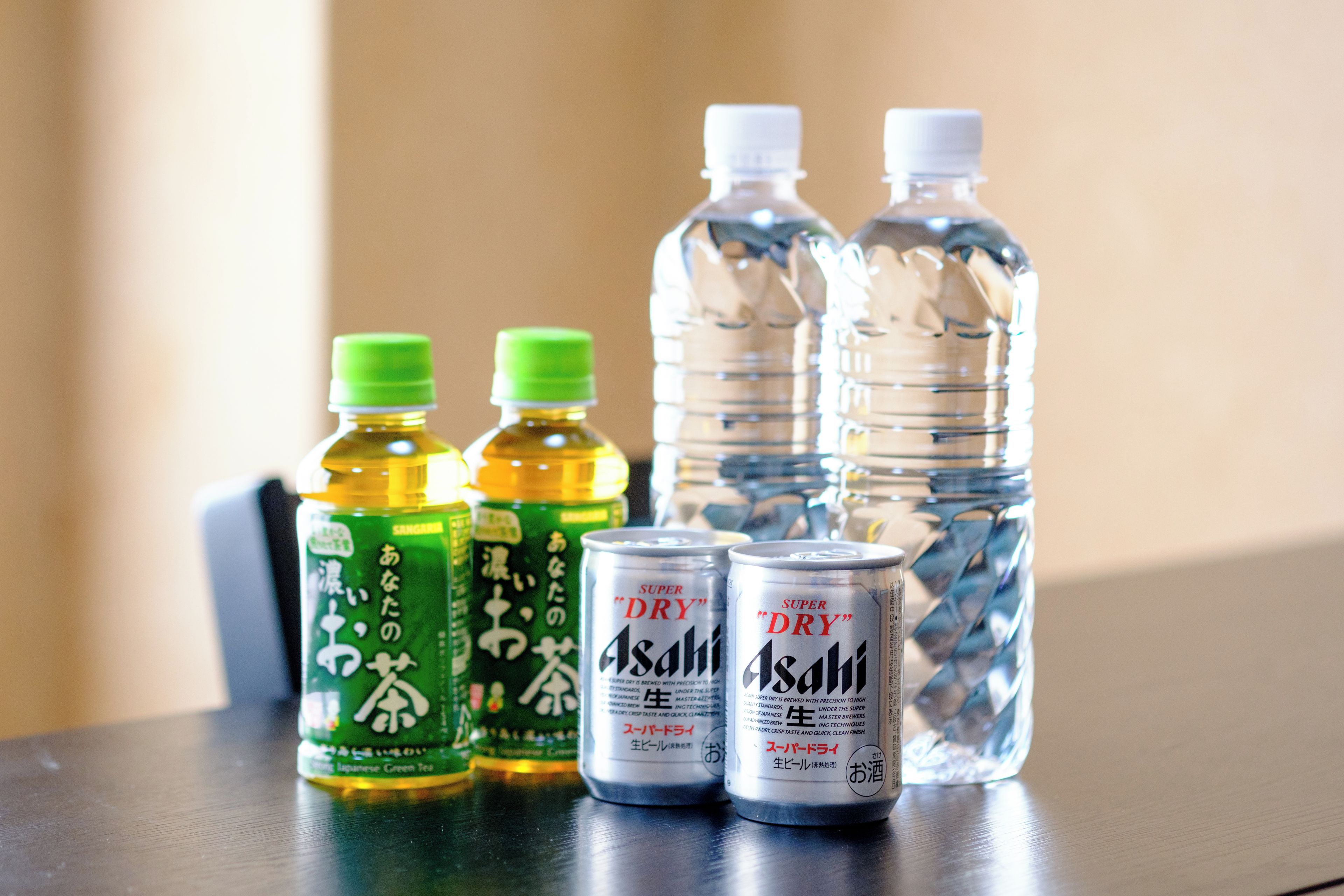 Une table sur laquelle se trouvent diverses bouteilles et canettes de boissons.
