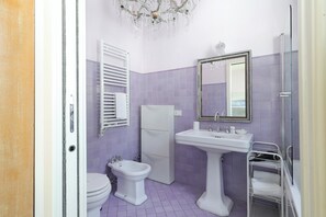 A bathroom with a toilet, bidet, sink, and a glass shower enclosure. - Delightful Family Flat with Terrace (Milan)