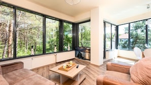 A modern living room with large windows, a fireplace, and a cozy seating area. - Violino 6 Os b Nowoczesny 5 min do Pla y (Trzebiatow)