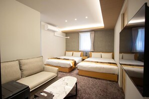 Une chambre d’hôtel avec deux lits, un canapé, un bureau et un grand miroir.