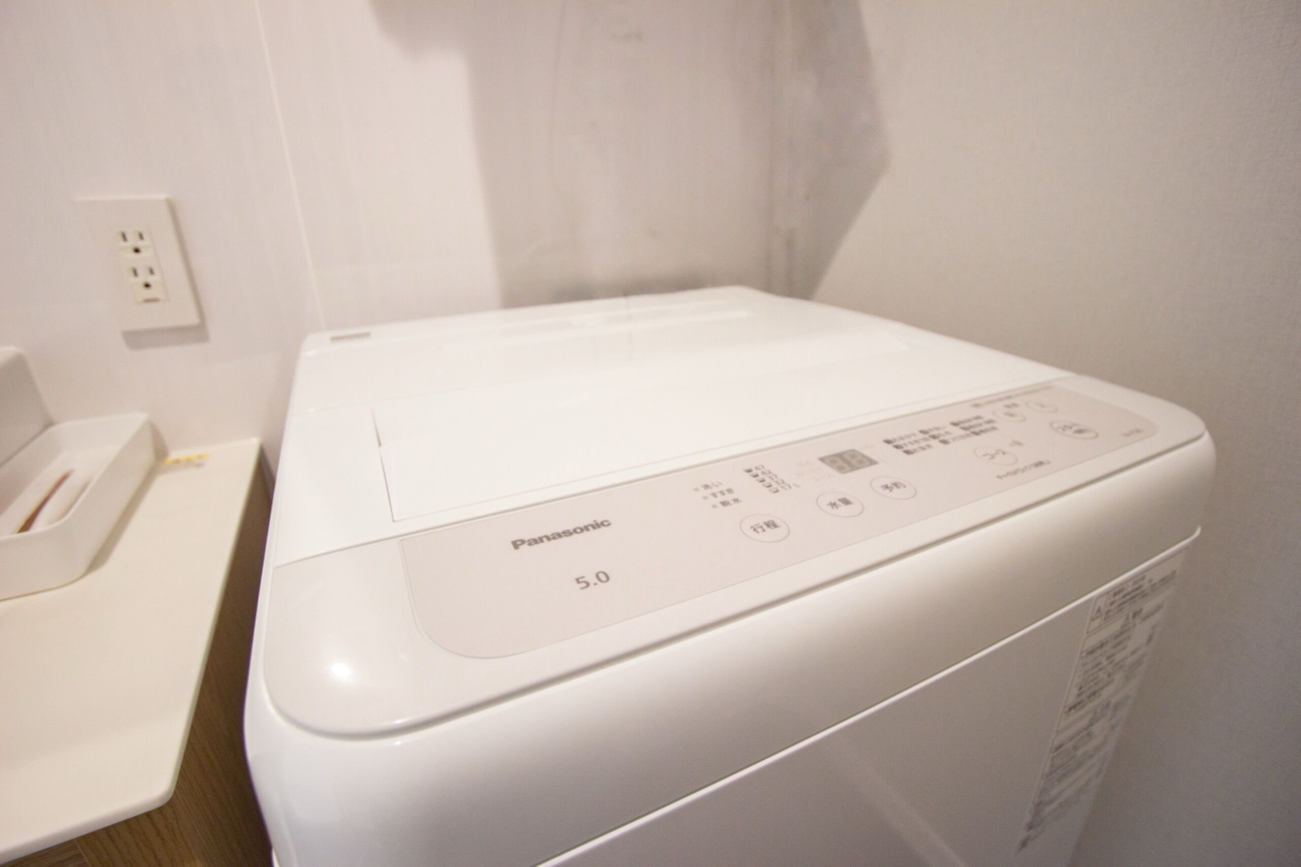 A white washing machine with a control panel labeled "Panasonic 50".