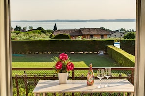 A balcony with a table, a bottle, and glasses.