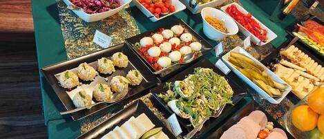 A buffet table with various food items including salads, fruits, and appetizers.