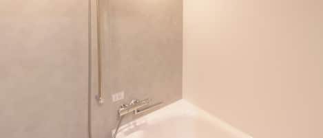 Un baño moderno con cabina de ducha, bañera y toallero.
