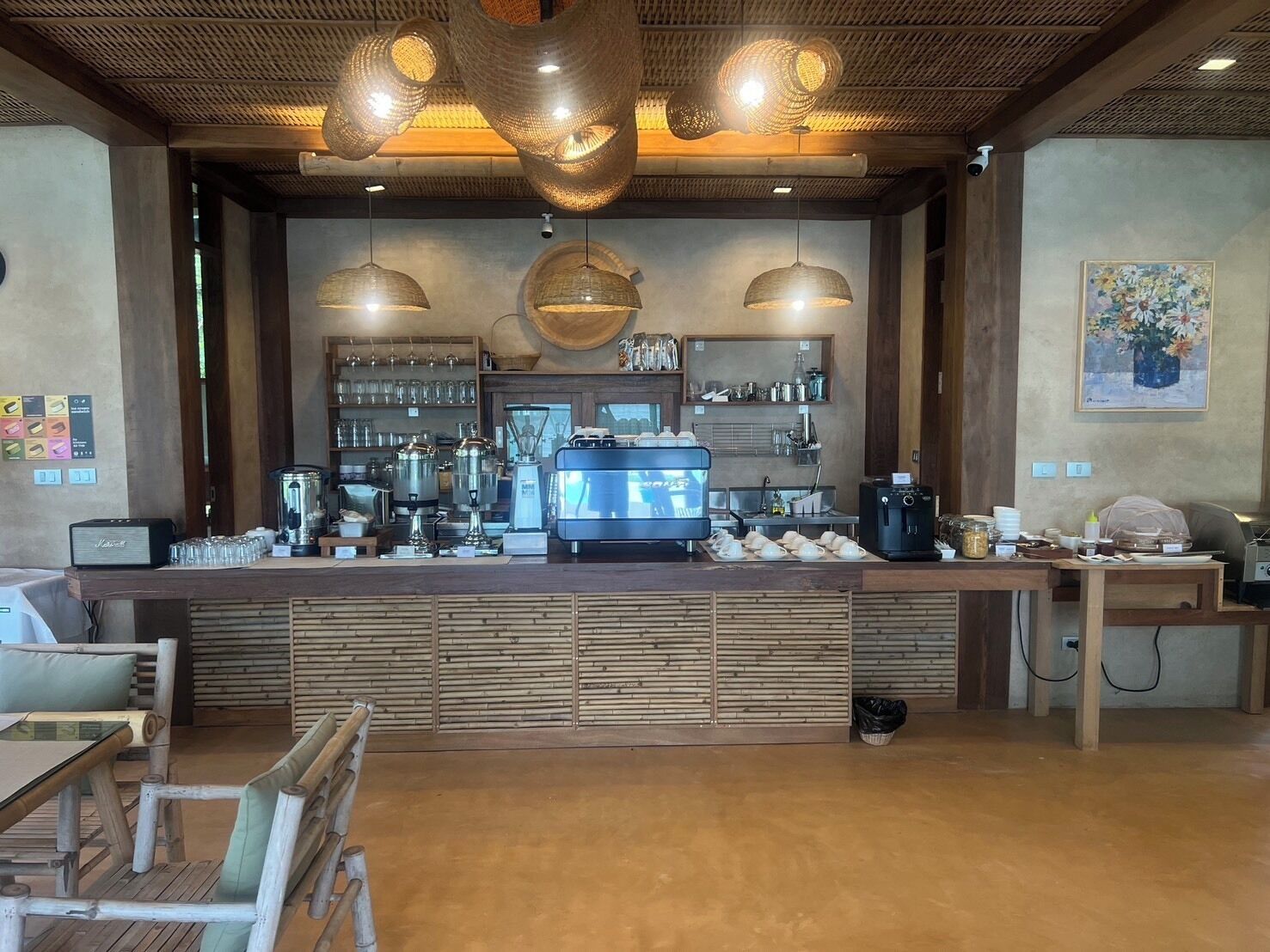 Ein Café mit Holztresen, Kaffeemaschinen und hängenden Lampen.