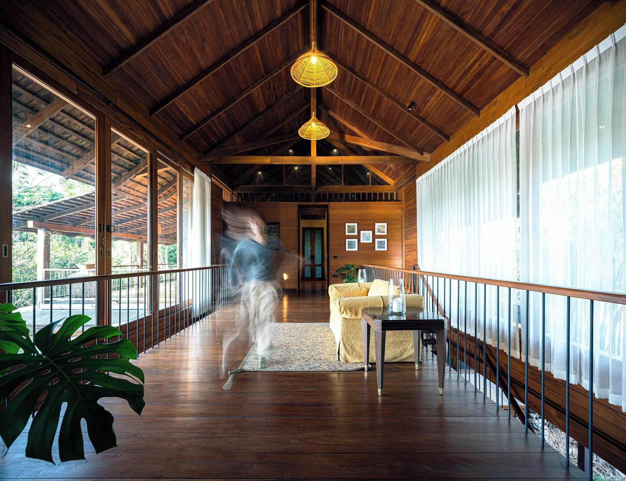 Una habitación amplia con techo de madera, ventanas grandes y vistas al exterior.